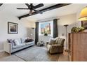 Living room with comfortable seating, accent rugs, dark wood beams, and natural light from the window at 238 Tampa W Ave # 217, Venice, FL 34285