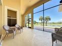 Bright lanai with wicker seating and expansive windows overlooking scenic waterfront views at 23901 Waverly Cir, Venice, FL 34293