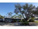 Charming single-story home with a gravel yard and a large tree providing shade at 332 E Langsner St, Englewood, FL 34223
