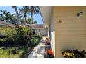 Front walkway leading to a cozy home entrance, surrounded by tropical plants and flowers at 334 Pembroke S Ln # 219, Venice, FL 34293