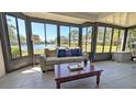 Relaxing sunroom with large windows offering serene water views and comfortable seating at 334 Pembroke S Ln # 219, Venice, FL 34293