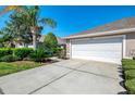 Charming home featuring a two-car garage, manicured landscaping, and a well-maintained lawn at 3459 Lakewood Blvd, North Port, FL 34287
