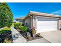 Well-maintained home exterior with a two-car garage, lush greenery, and a tidy walkway at 3459 Lakewood Blvd, North Port, FL 34287