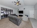 Bright living room with plush carpet, a ceiling fan, and a comfortable gray sectional sofa at 4070 Kincord Ln, North Port, FL 34287