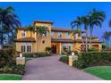 Elegant two-story home with lush landscaping, a brick driveway, and a grand entrance, creating a welcoming curb appeal at 416 Baycrest Dr, Venice, FL 34285