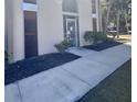 Building entrance with glass door, mature landscaping, and well-maintained sidewalk at 519 Albee Farm Rd # 116, Venice, FL 34285
