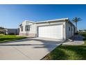 Single Gathering home with a two-car garage and an extra-long driveway on a sunny day at 6037 Shearwater Dr, Englewood, FL 34224