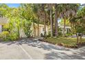 Charming single-story home with well-manicured lawn, mature tropical foliage, and inviting front entrance at 614 N Jefferson Ave # 27, Sarasota, FL 34237