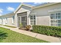 Single-story home with a tile roof, and manicured hedges along a well-maintained lawn and sidewalk at 651 Back Nine Dr, Venice, FL 34285