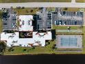 Aerial view of condo complex with parking, tennis court and access to the water at 66 Boundary Blvd # 275, Rotonda West, FL 33947