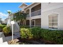 Condo exterior with a large window, lush plants, and second story balcony at 7104 L Pavia Blvd # 7104, Venice, FL 34292