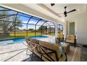 Screened-in patio featuring comfortable seating with a ceiling fan overlooking the sparkling pool and backyard at 7407 S Blue Sage, Punta Gorda, FL 33955