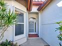 Close up of the white front door with a tiled entryway of a well maintained home at 904 Harbor Town Dr, Venice, FL 34292