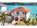 Stunning aerial view of a waterfront home boasting a red tile roof, balcony, and a tranquil backyard at 919 Key Way, Nokomis, FL 34275