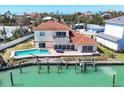 Expansive backyard view with a large pool, dock with a boat lift, and serene waterfront vistas at 919 Key Way, Nokomis, FL 34275