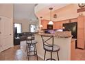 Open kitchen featuring a breakfast bar with stools, granite countertops, and modern appliances at 1000 Gardens Edge Dr # 1023, Venice, FL 34285