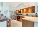 Cozy kitchen with stainless steel appliances, wood cabinets, and adjacent breakfast area at 109 Southampton N Pl # 245, Venice, FL 34293