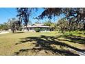 A single-story home featuring a well-manicured lawn and mature landscaping at 1110 Gladstone Blvd, Englewood, FL 34223