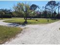 Gravel driveway with a circle feature and a flagpole in the front yard at 1110 Gladstone Blvd, Englewood, FL 34223