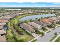 A high-angle view of homes, a lake, palm trees, and landscaping under blue skies at 13032 Oriago St, Venice, FL 34293