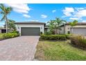 A beautiful single-Gathering home showcasing a manicured lawn and a brick-paved driveway at 13032 Oriago St, Venice, FL 34293