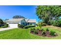 Beautiful single-story home with lush landscaping, flowering plants, and a well-maintained lawn enhancing its curb appeal at 1400 Colony Pl, Venice, FL 34292