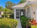 Inviting home entrance with lush landscaping, a screened porch, and a decorative pineapple statue at 1567 Monarch Dr, Venice, FL 34293