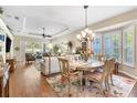 Sun-drenched living space with hardwood floors, ceiling fan and a seamless flow to the dining area at 1627 Lancashire Dr, Venice, FL 34293