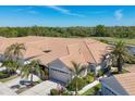 A lovely front exterior showing the tile roof of these charming attached villas with two car garage and lush landscaping at 1853 San Silvestro Dr, Venice, FL 34285