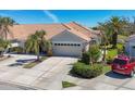 An appealing exterior view highlighting the two-car garage, tile roof, and well-maintained landscaping at 1853 San Silvestro Dr, Venice, FL 34285