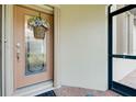 Inviting front door with a glass panel and a decorative wreath, next to a screened entry at 20176 Tesoro Dr, Venice, FL 34293