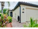 Charming home featuring a lush garden, brick walkway and a cozy, screened front door at 20176 Tesoro Dr, Venice, FL 34293