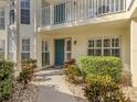 The condo's welcoming entrance with a well-maintained walkway, manicured landscaping, and a pop of color from the front door at 206 Silver Lake Dr # 105, Venice, FL 34292