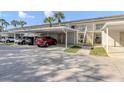 Multiple cars parked under covered parking spots outside of units in a sunny exterior shot of the condominium building at 206 Silver Lake Dr # 105, Venice, FL 34292
