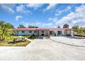 Charming single-story home featuring a unique red roof, a spacious driveway, and welcoming curb appeal at 2211 Englewood Rd, Englewood, FL 34223