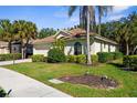 A well-maintained single Gathering home showcasing mature palm trees and meticulously manicured shrubbery at 2292 Harrier Way, Nokomis, FL 34275