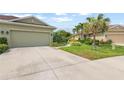 Charming home exterior with a well-maintained lawn, mature landscaping, and a two-car garage at 371 Capulet Dr, Venice, FL 34292