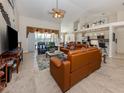 Spacious living room featuring tile floors, a ceiling fan, and comfortable leather furniture at 4358 Via Del Villetti Dr, Venice, FL 34293
