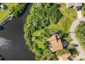 Aerial view of a brown roof house situated next to a lake and lush foliage at 440 Monza Ave, North Port, FL 34287