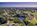 Scenic aerial view of a residential neighborhood with a small river and lush greenery at 440 Monza Ave, North Port, FL 34287