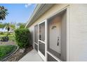 Home entrance featuring a screen enclosed porch and white front door at 4553 Fairway Dr, North Port, FL 34287
