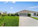 View of home exterior featuring well-manicured lawn, lush landscaping, and driveway at 4553 Fairway Dr, North Port, FL 34287