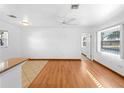 Open-concept living space with hardwood floors, large window, and partial kitchen view at 510 Airport E Ave # 2D, Venice, FL 34285