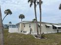 This one-story home features window awnings, a back patio, and a few beautful palm trees at 530 Via Veneto, Venice, FL 34285