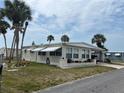 This cozy one-story home features window awnings, landscaping, and is beautifully landscaped with palm trees at 530 Via Veneto, Venice, FL 34285