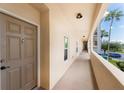 Hallway view featuring unit entry door, lighting, and exterior views of landscaping at 8403 Placida Rd # 205, Placida, FL 33946