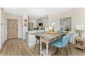 Kitchen and dining area with blue chairs, hardwood floors and modern white countertops at 8403 Placida Rd # 205, Placida, FL 33946