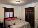 Bedroom featuring a comfortable queen bed with brown curtains for privacy at 8629 Aero Ave, North Port, FL 34287