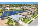 An aerial view showing the backyard water feature and many homes in this desirable, well-maintained community at 863 Macaw Cir, Venice, FL 34285