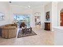 Bright living room with tile floors, high ceilings, and a large window offering scenic backyard views at 867 Macaw Cir, Venice, FL 34285